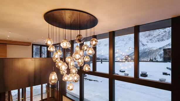 Un intérieur moderne avec de grandes fenêtres donnant sur un paysage montagneux enneigé.