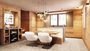 Une cuisine moderne avec des meubles en bois, un coin repas doté d’un banc blanc rembourré et une grande fenêtre offrant une vue dégagée.