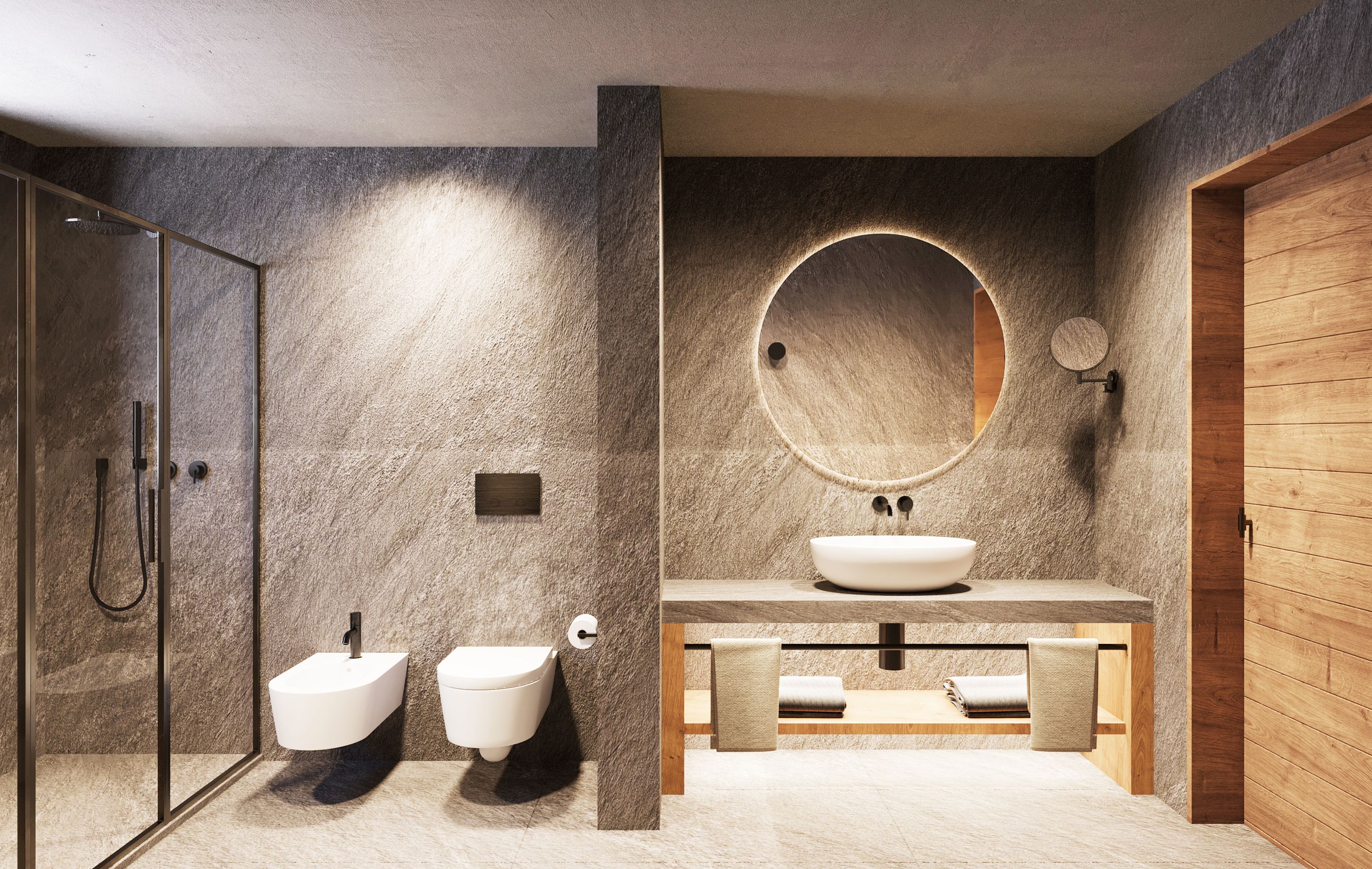 A modern bathroom with a glass shower enclosure, a freestanding bidet, a round mirror, and a wooden vanity with a sink.
