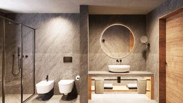 Un baño moderno con cabina de ducha de vidrio, un bidé independiente, un espejo redondo y un mueble de tocador de madera con lavabo.