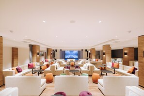 A spacious lounge area with multiple seating options, a large screen, and a modern design. - Valtur Cervinia Cristallo Ski Resort (Valtournenche)