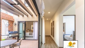 A modern hotel room with a patio area, a dining table, and a grill.