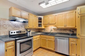 Enjoy cooking in this well-equipped kitchen with a range hood, oven, and dishwasher.