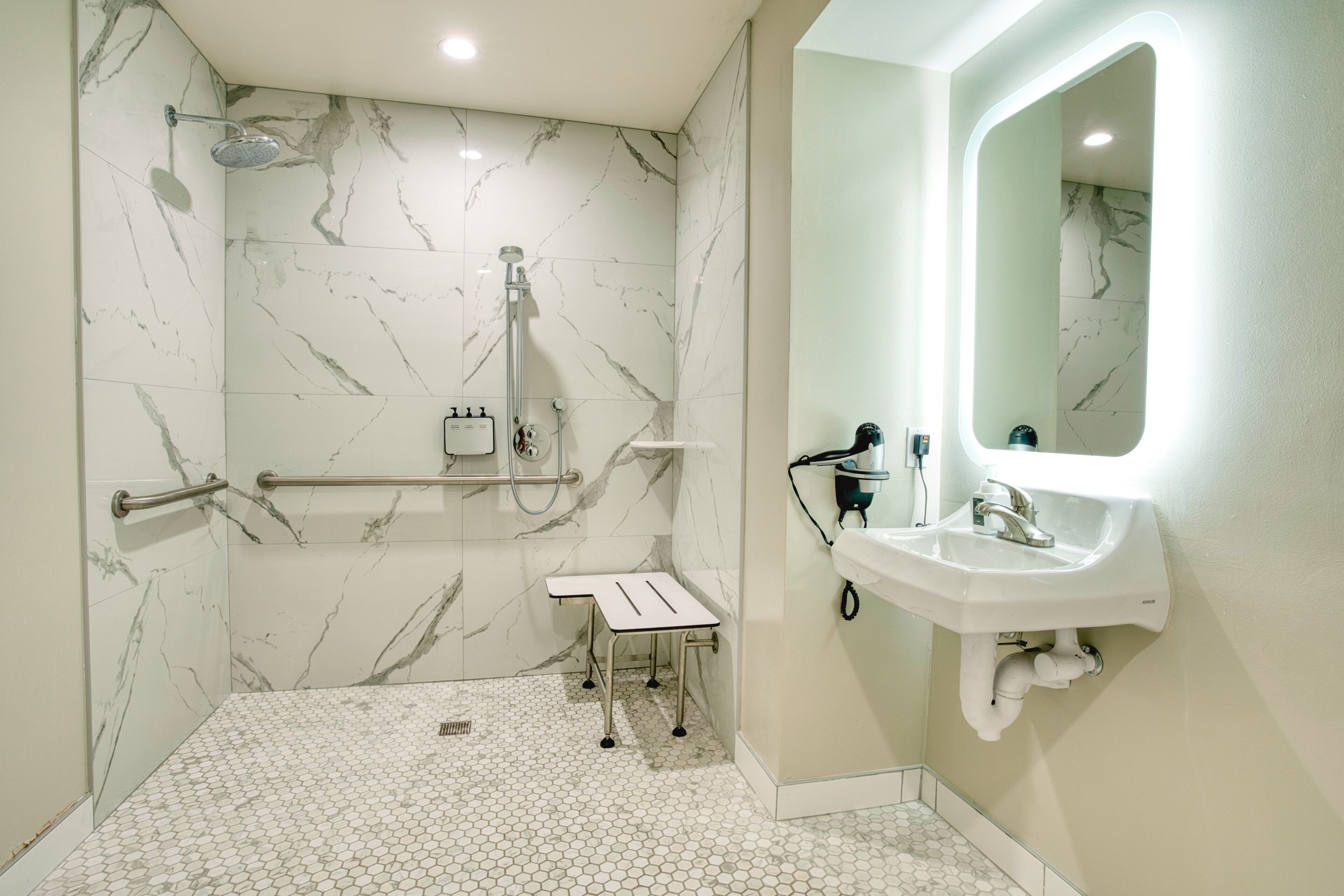 A modern bathroom with a shower, a sink, and a mirror.