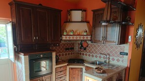 Une cuisine compacte avec des meubles en bois, un four encastré et un évier.