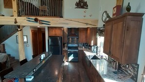 Una cocina amplia con armarios de madera, una isla grande y un comedor con sillas.