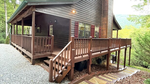 A wooden cabin with a covered porch and a chimney, surrounded by gravel and mulch. - Little Bear Cove in the Enchanted Valley of Young Harris Ga (Young Harris)