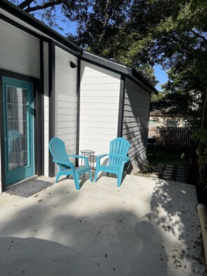 Relax in the backyard with a patio, Adirondack chairs, and a small table.