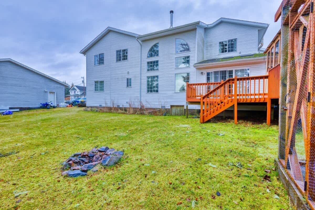 A two-story building with a covered porch and a grassy yard.