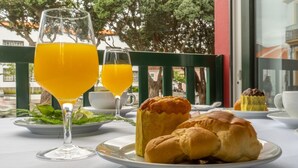Et bord dækket med croissanter, et glas appelsinjuice og en kop kaffe.