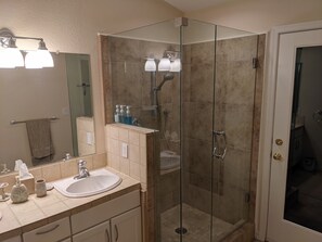 Een bad/douchecombinatie, handdoeken, zeep, shampoo