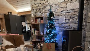 A cozy living room with a stone fireplace, a Christmas tree, and a wooden coffee table with festive decorations. - PRESTIGE: RARE DUPLEX for 6 to 10 people (Saint-Sorlin-d'Arves)