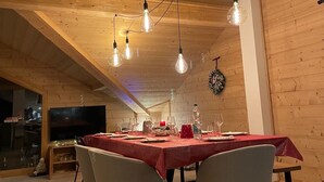A dining area with a wooden ceiling, a red tablecloth, and modern chairs. - PRESTIGE: RARE DUPLEX for 6 to 10 people (Saint-Sorlin-d'Arves)