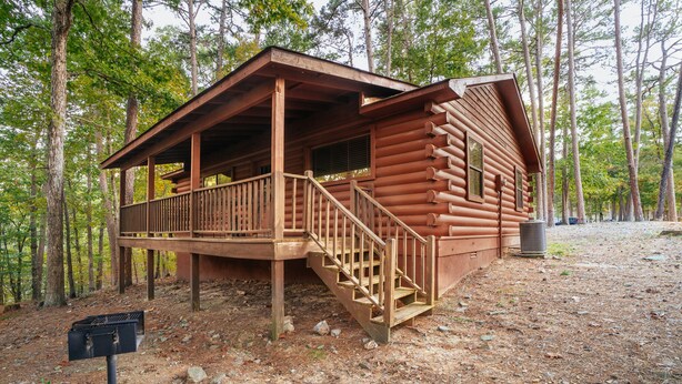 A log cabin with a porch and stairs leading to the entrance.