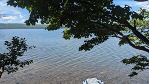 Un lago transparente con un pequeño bote inflable en la orilla.