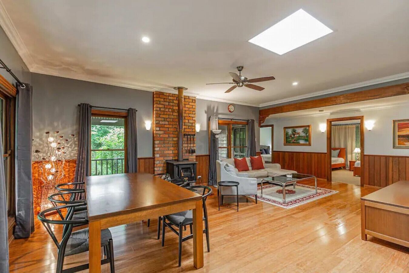 A spacious living area with a wooden dining table, a sofa, and a fireplace.