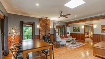 A spacious living area with a wooden dining table, a sofa, and a fireplace.