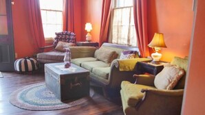 A cozy living room with a sofa, armchairs, a small table, and a lamp. - Walking distance to French Quarter and Frenchmen Street with Pool!  (New Orleans)