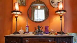 A room with a wooden dresser, two ornate lamps, a mirror, and various decorative items on the dresser. - Walking distance to French Quarter and Frenchmen Street with Pool!  (New Orleans)