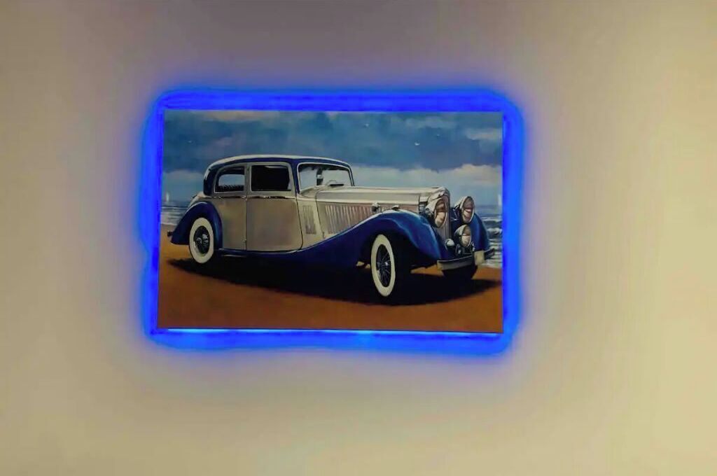 Un coche antiguo en una vitrina con un borde de luz azul.