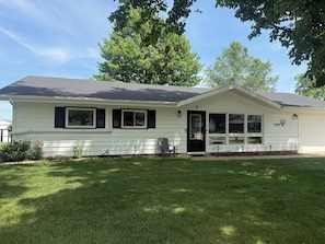 A single-story house with a front porch, a garage, and a mailbox.