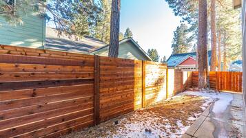 A wooden fence, a snow-covered ground, and a clear sky.