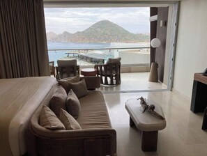Relax on the balcony with a view of the coastal landscape, featuring a mountain and beach.