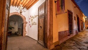 A historic building with a large wooden door, a chandelier, and a sign that reads "Meson Garcia." - Hotel Mesón de Sara (Querétaro)