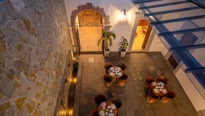A rooftop terrace with stone walls, a central archway, and tables set for dining. - Hotel Mesón de Sara (Querétaro)