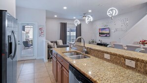 A modern kitchen with granite countertops, stainless steel appliances, and a built-in dishwasher.