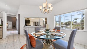 Enjoy meals with a view of the water and palm trees from this dining area with a large window.