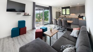 A modern living room with a sofa, a coffee table, and a TV mounted on the wall.