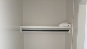 A small, white closet with a wooden floor, a shelf, and a towel on top. - Modernized Studio Apartment in Gadsden, AL (Gadsden)