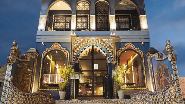 A hotel with a traditional architectural style, featuring arched windows and a decorative facade.