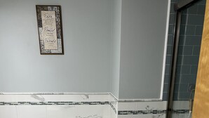 A bathroom with a toilet, sink, and shower area. - Park-like and sports bar - close to MSU (Lansing)
