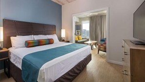 Une chambre d’hôtel avec un grand lit, une télévision, un bureau et une vue sur la ville.