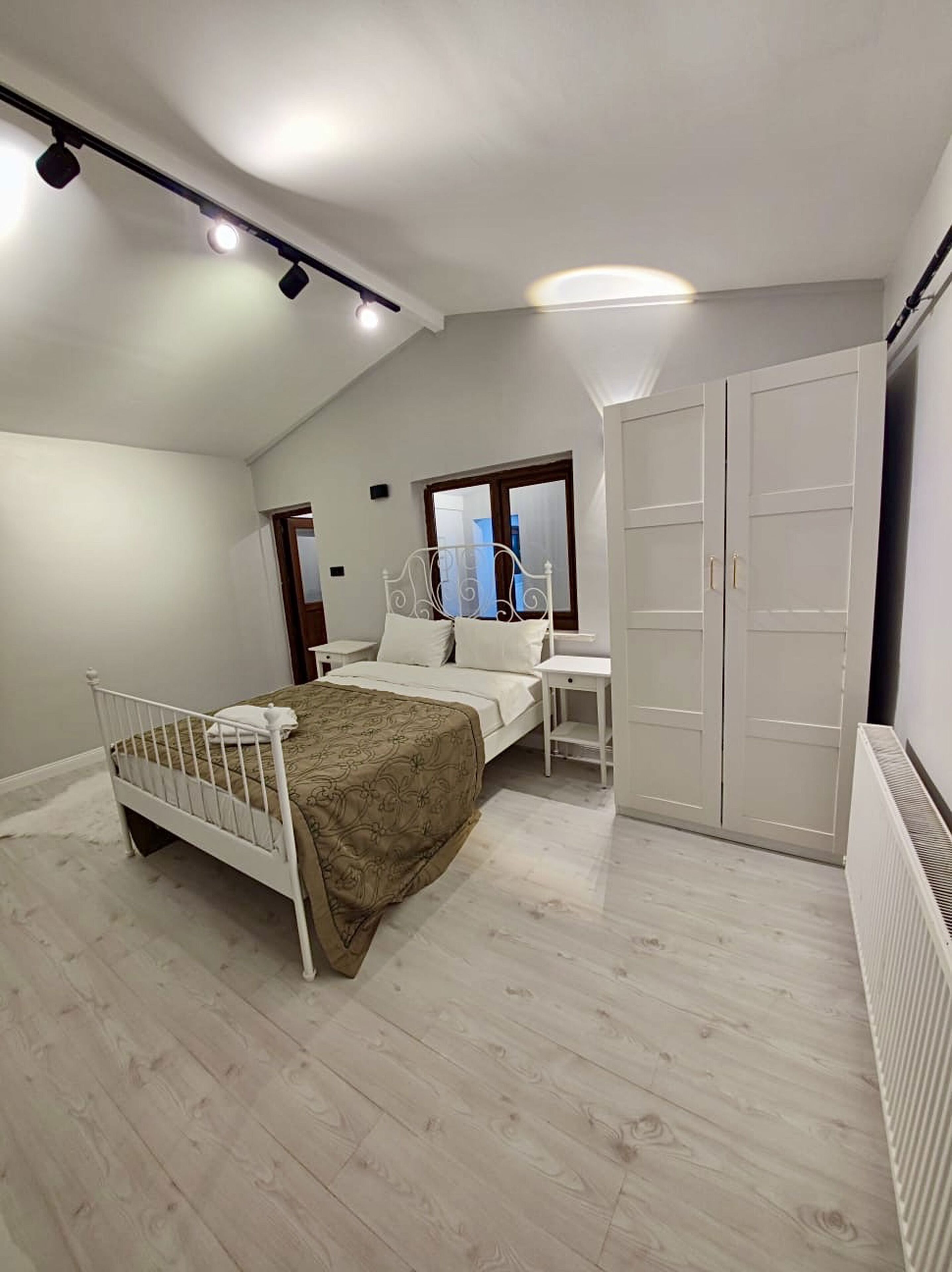 Un dormitorio con cama, mesita de noche, armario y ventana con vistas.