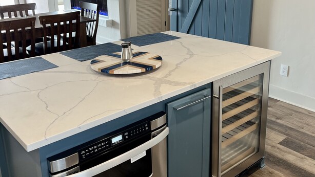 A modern kitchen with a built-in oven, dishwasher, and a large island with a marble countertop. - Possum Kingdom Lake Luxury, Upgraded Lakefront Condo w Breathtaking Water View (Graford)