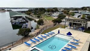 A swimming pool with lounge chairs and a view of a marina. - Possum Kingdom Lake Luxury, Upgraded Lakefront Condo w Breathtaking Water View (Graford)