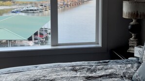 A bedroom with a large window overlooking a body of water and a dock. - Possum Kingdom Lake Luxury, Upgraded Lakefront Condo w Breathtaking Water View (Graford)