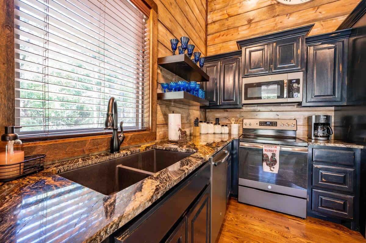Una cocina moderna con armarios de madera oscura, electrodomésticos de acero inoxidable y encimera de granito.