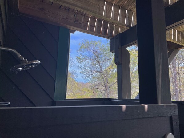 A wooden structure with a window, a metal railing, and a view of trees and sky. - Chappy - Family Beach House (Edgartown)