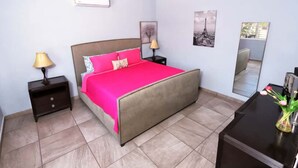 A bedroom with a bed, nightstands, a dresser, and a mirror. - Relaxing Getaway w/ Pool, Billiards, Steps to the Beach – Perfect for Families! (Puerto Peñasco)