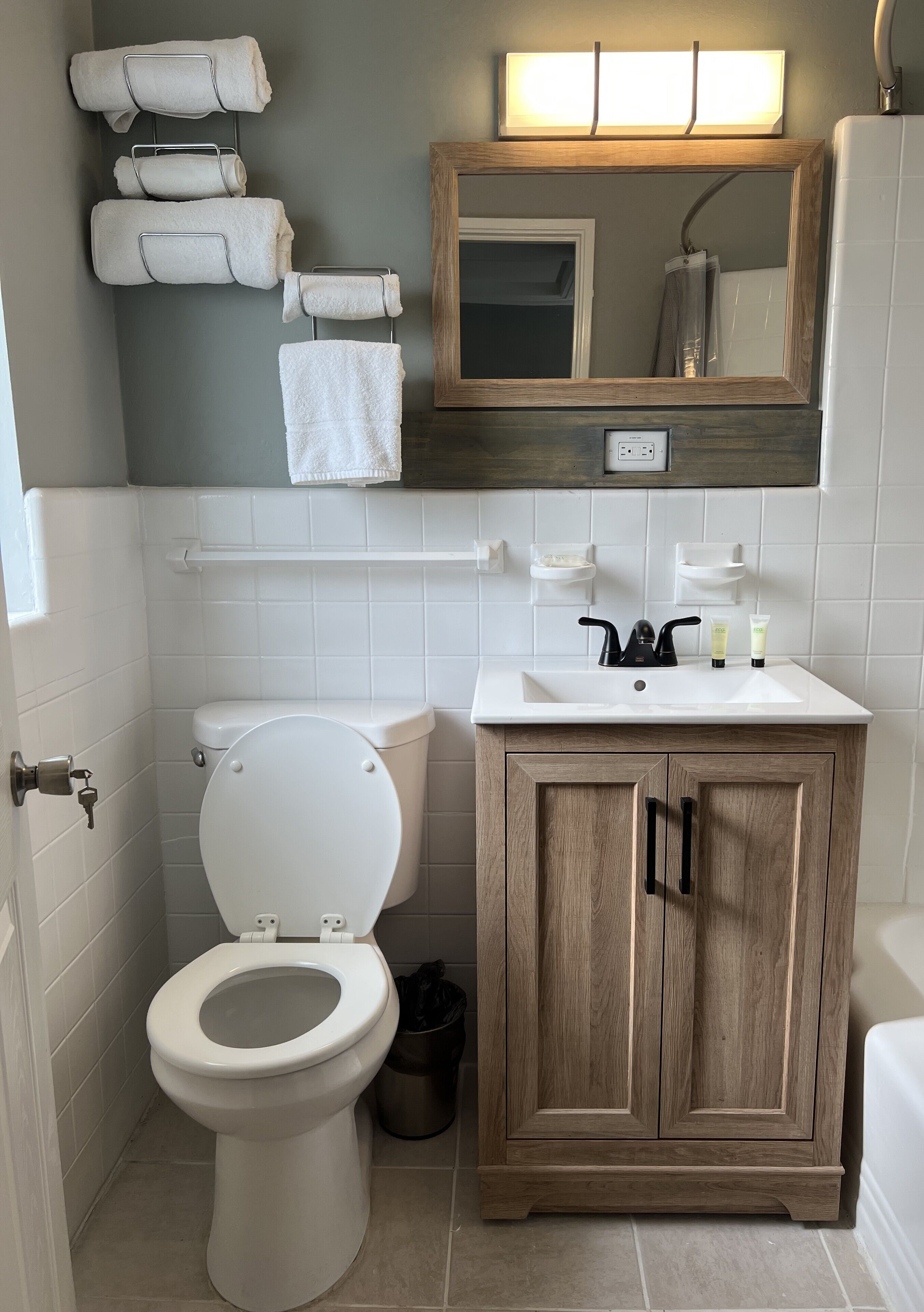 Une salle de bain équipée de toilettes, d’un lavabo et d’un meuble en bois.