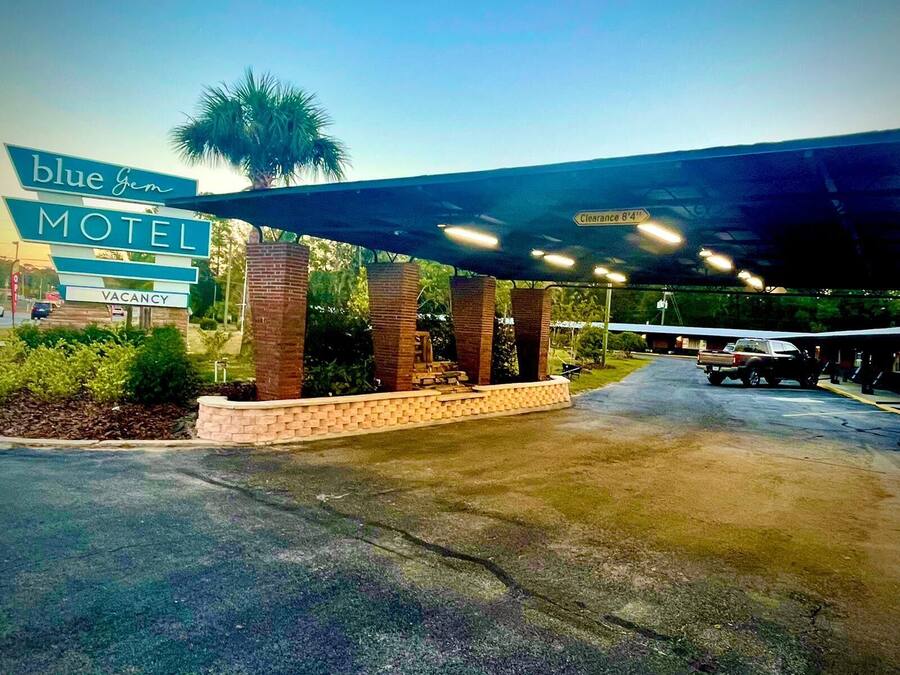 A motel entrance with a covered parking area, a sign indicating a 8'4" clearance, and a 'VACANCY' sign.