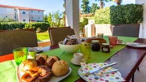 Ein Essplatz im Freien mit Gebäck, Brot und Beilagen.