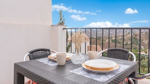 Une table de balcon offrant une vue sur un paysage montagneux.