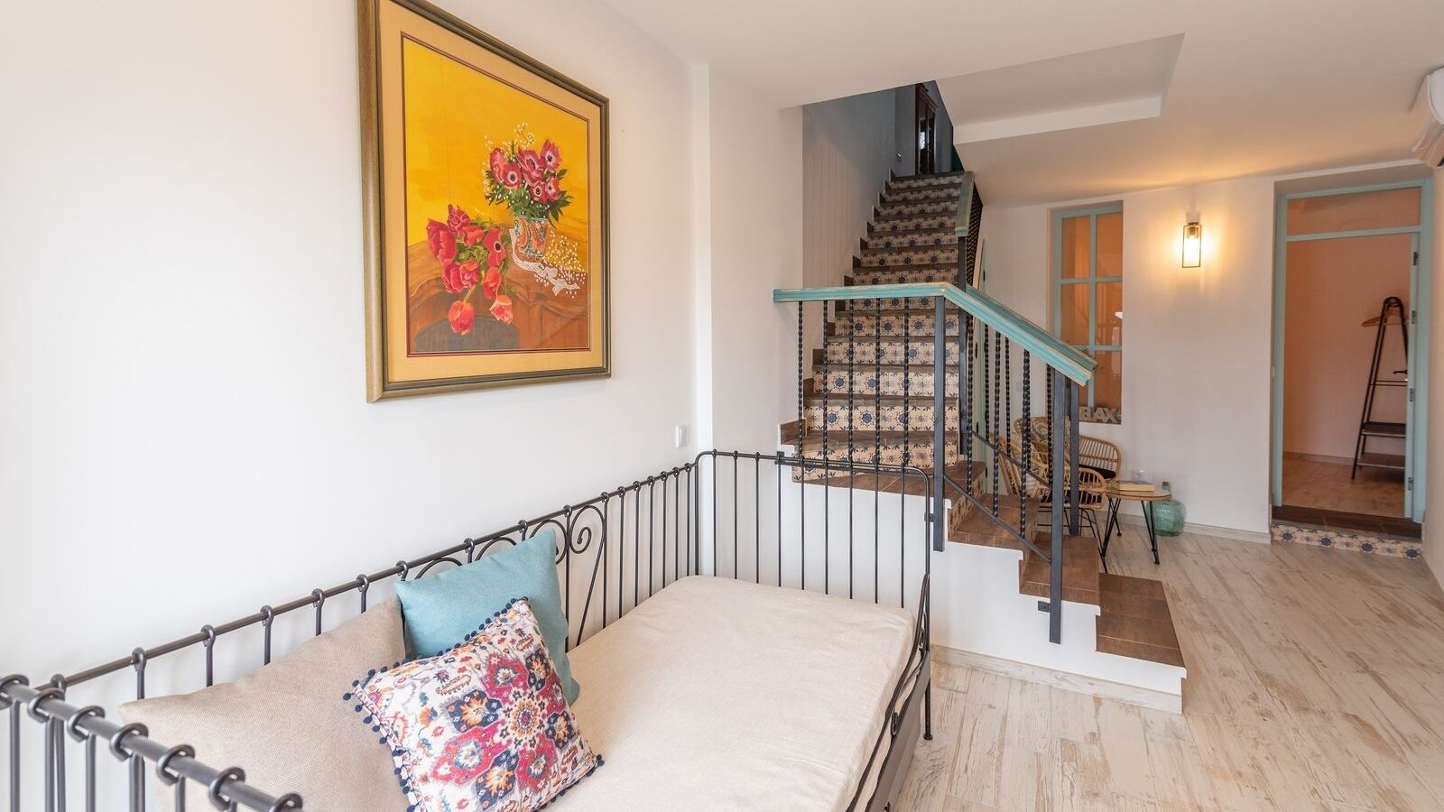 Ein Schlafzimmer mit Bett, Treppe und einem Gemälde an der Wand.