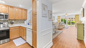 A modern kitchen with wooden cabinets, stainless steel appliances, and a dining area with a view. - NEW LISTING!Stunning Sea Place Renovated -Oceanview 1st floor 2bd/bath (St. Augustine)
