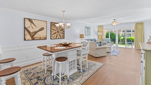 A spacious living area with a dining table, bar stools, and a sofa. There are large windows offering a view of the outdoors. - NEW LISTING!Stunning Sea Place Renovated -Oceanview 1st floor 2bd/bath (St. Augustine)